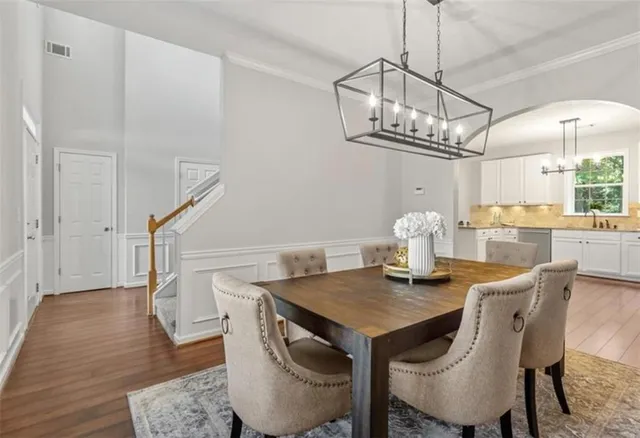 a view of a dining room with furniture a chandelier and wooden floor