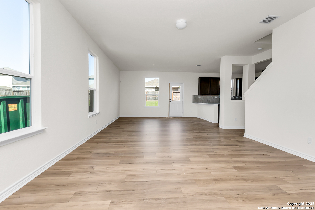 9515 Griffith Run Converse, TX 78109 - Photo 4 of 18 a view of an empty room with wooden floor and a window