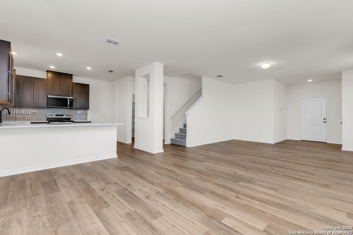 9515 Griffith Run Converse, TX 78109 - Photo 5 of 18 a view of kitchen with refrigerator microwave and wooden floor