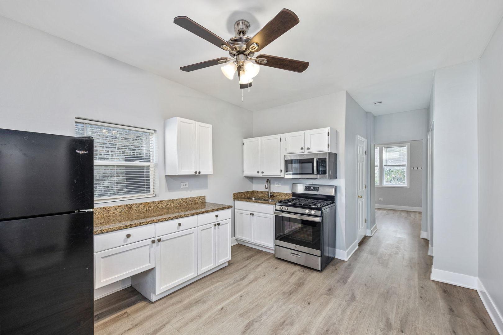 4418 West Armitage Avenue Chicago, IL 60639 - Photo 23 of 59 a kitchen with white cabinets and stainless steel appliances