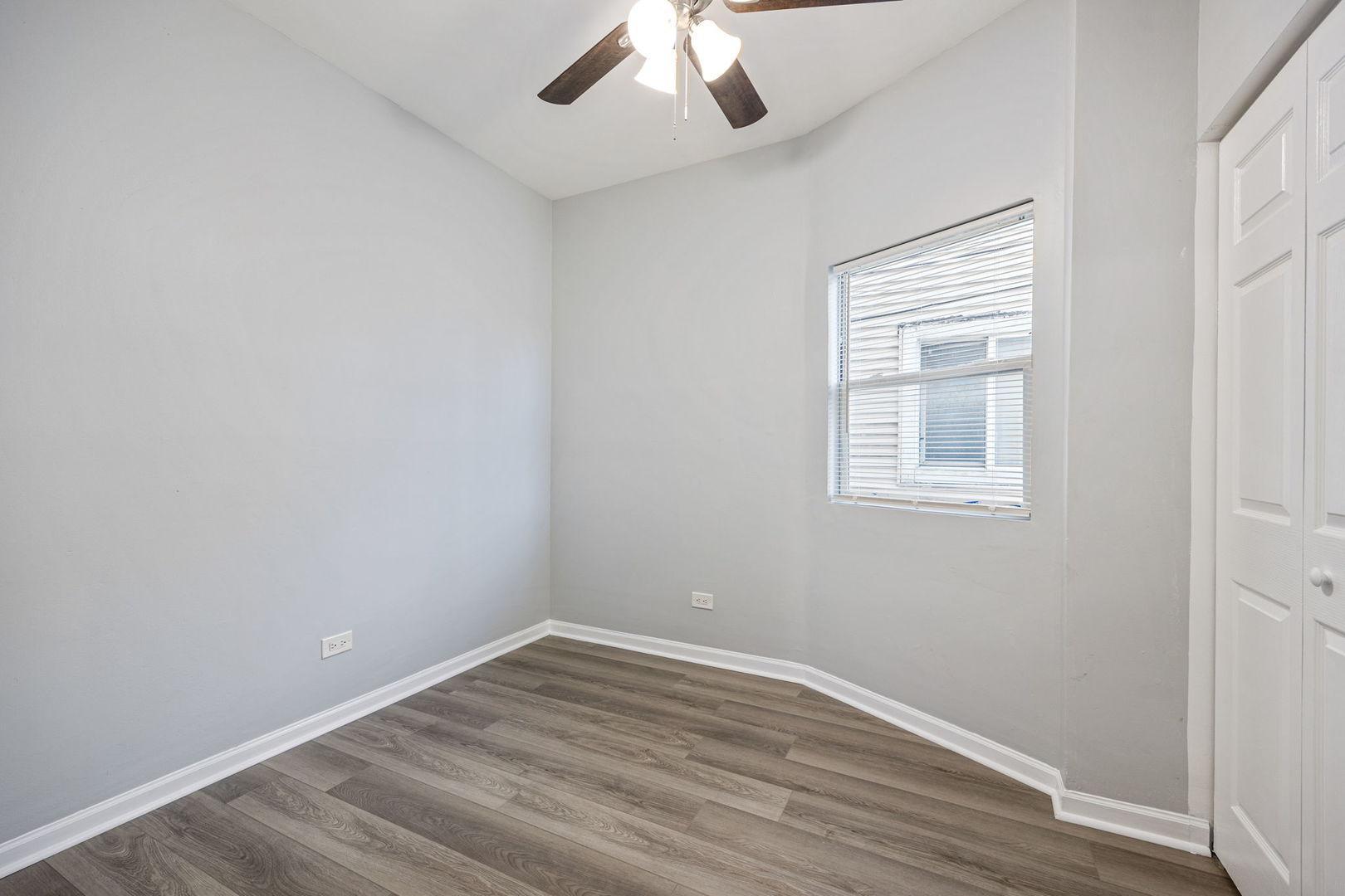4418 West Armitage Avenue Chicago, IL 60639 - Photo 29 of 59 an empty room with a window and wooden floor