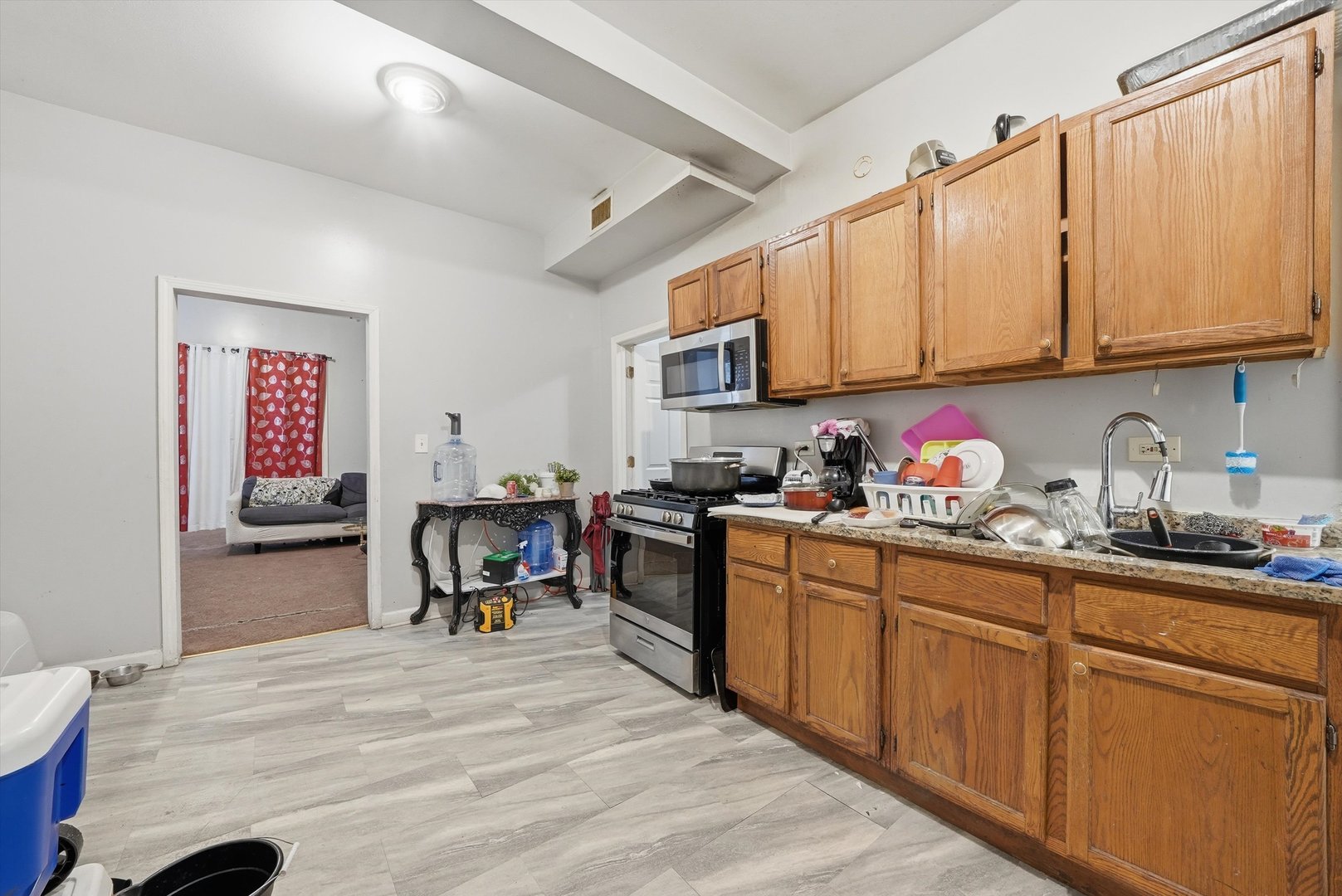 4418 West Armitage Avenue Chicago, IL 60639 - Photo 34 of 59 a kitchen with granite countertop a sink dishwasher a stove top oven a dining table and chairs with wooden floor