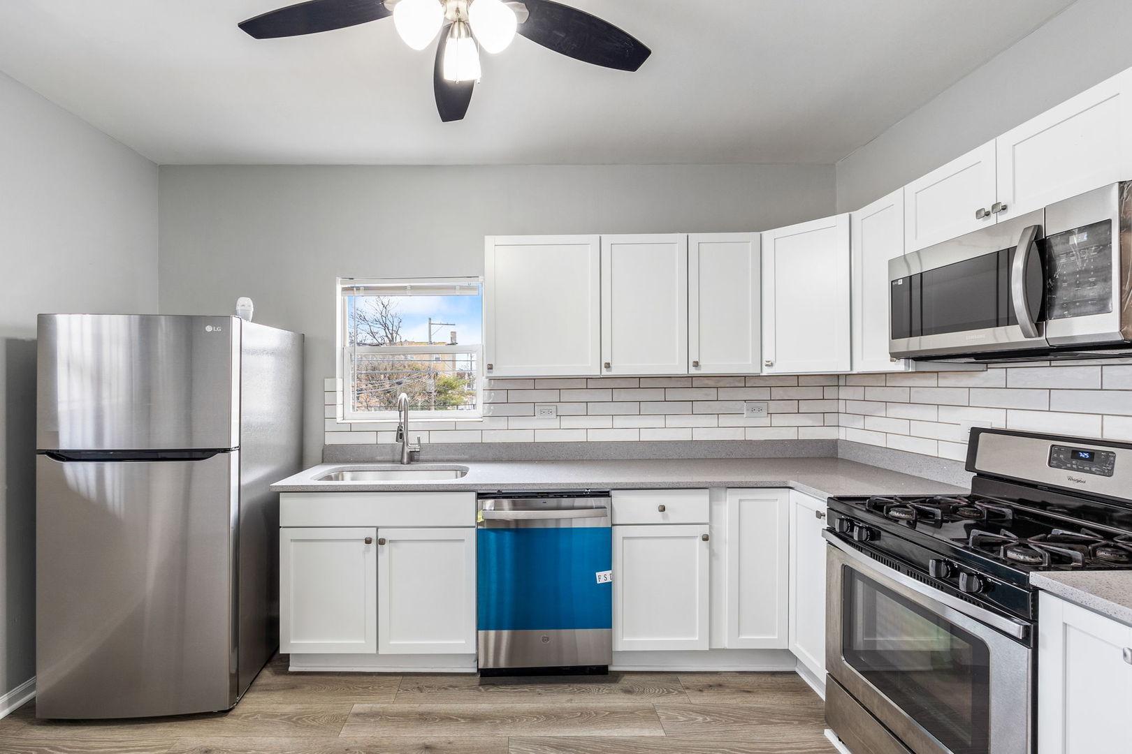 4418 West Armitage Avenue Chicago, IL 60639 - Photo 10 of 59 a kitchen with stainless steel appliances a stove a sink and a refrigerator