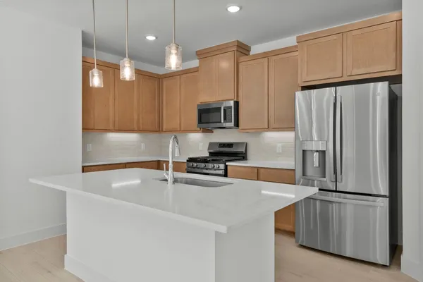 a kitchen with kitchen island a counter top space stainless steel appliances and cabinets