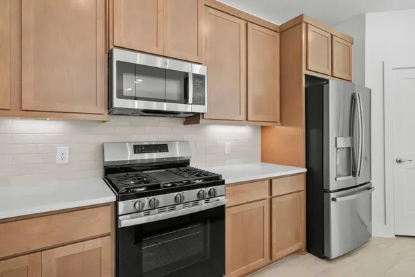 a kitchen with stainless steel appliances white cabinets and a stove top oven