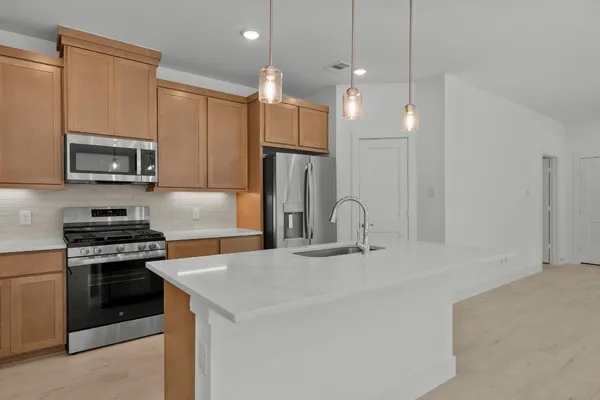 a kitchen with kitchen island a sink stainless steel appliances and cabinets