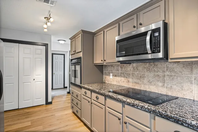 a kitchen with stainless steel appliances granite countertop a sink stove and refrigerator