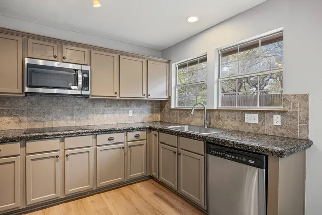 a kitchen with stainless steel appliances granite countertop a sink and microwave
