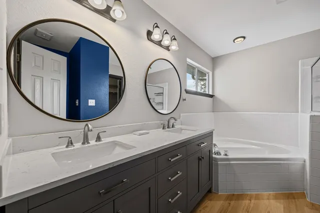 a bathroom with a granite countertop double vanity sink and a mirror