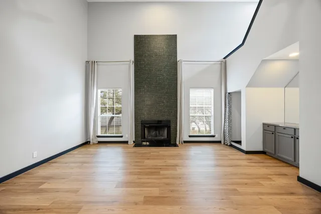 an empty room with windows and a fireplace