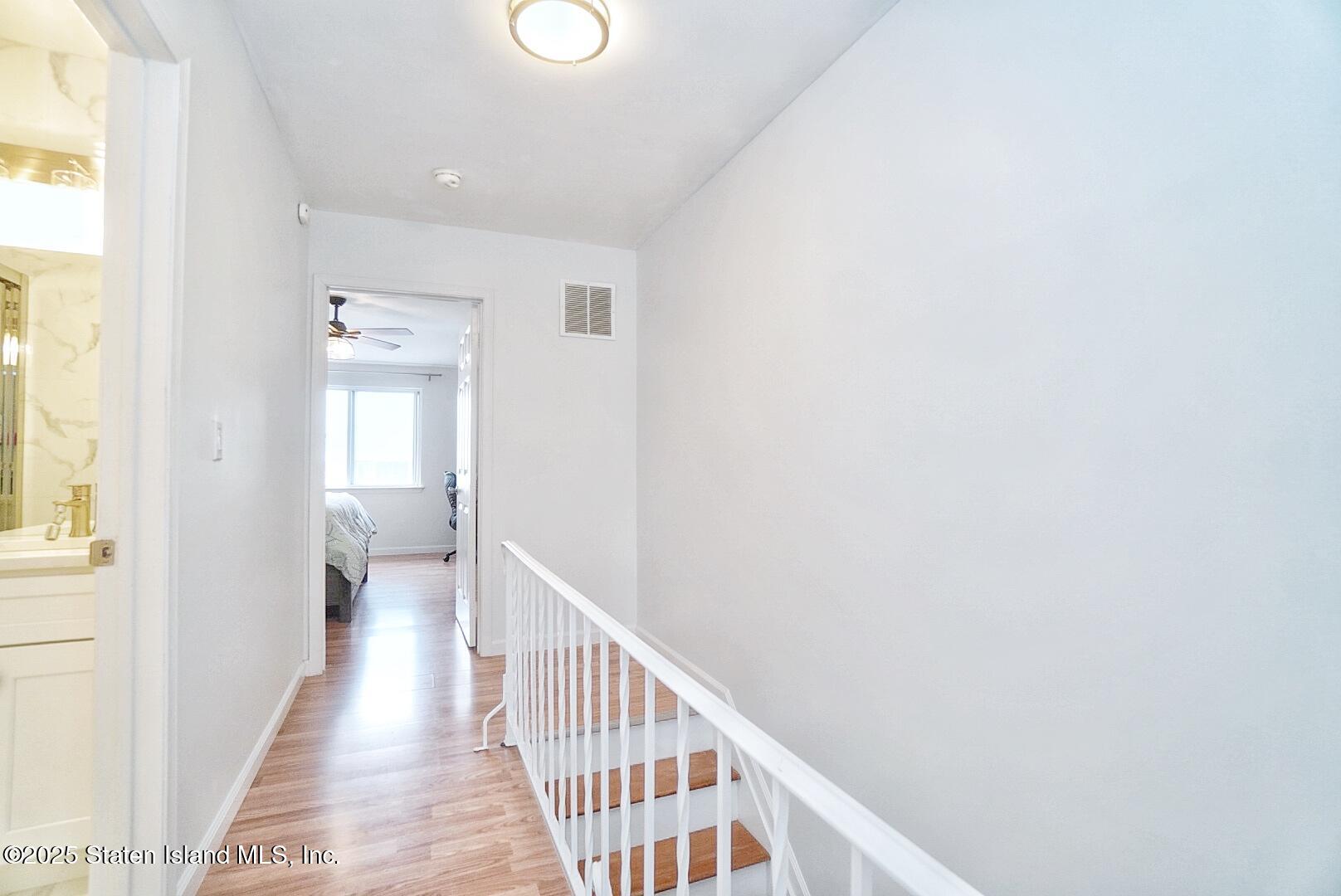 168 Rosedale Avenue Staten Island, NY 10312 - Photo 13 of 21 a view of a hallway with wooden floor and a bathroom