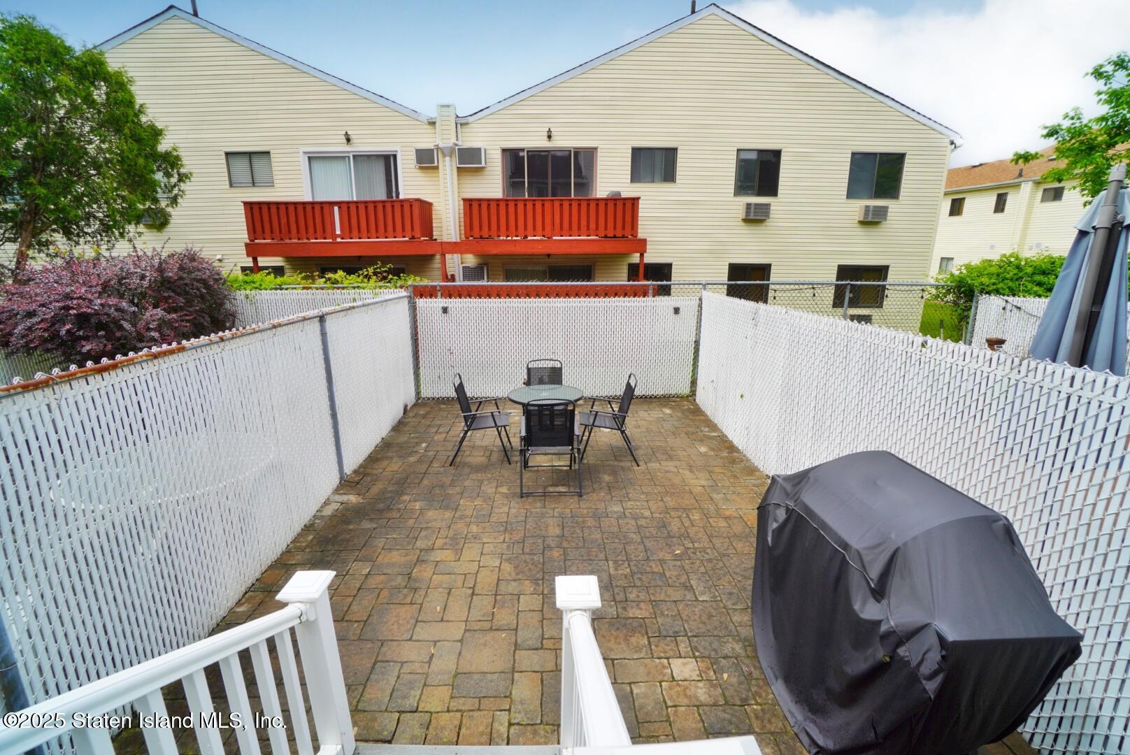 168 Rosedale Avenue Staten Island, NY 10312 - Photo 19 of 21 a view of a patio with table and chairs with wooden floor and fence