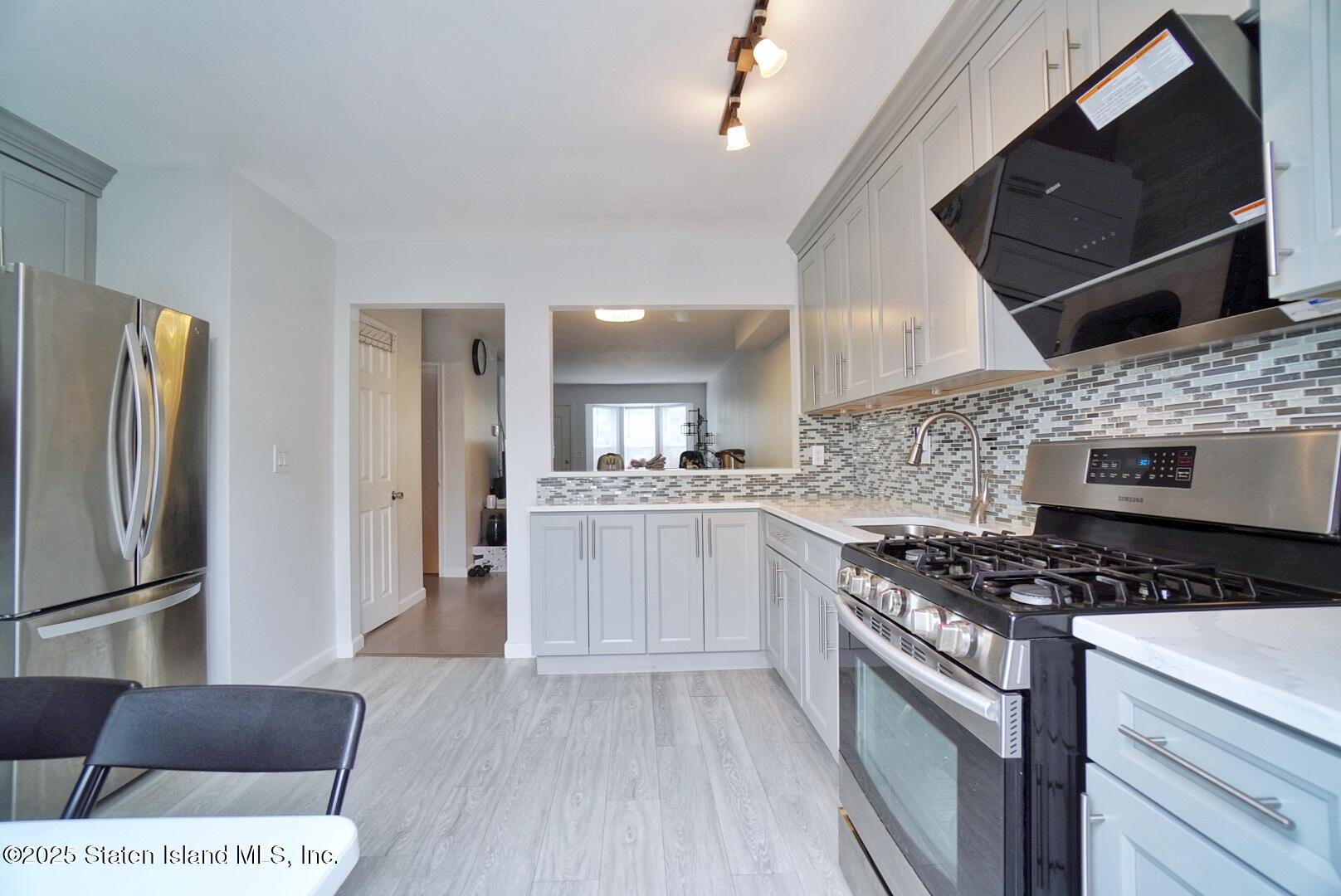 168 Rosedale Avenue Staten Island, NY 10312 - Photo 6 of 21 a kitchen with stainless steel appliances granite countertop a stove a refrigerator and a microwave