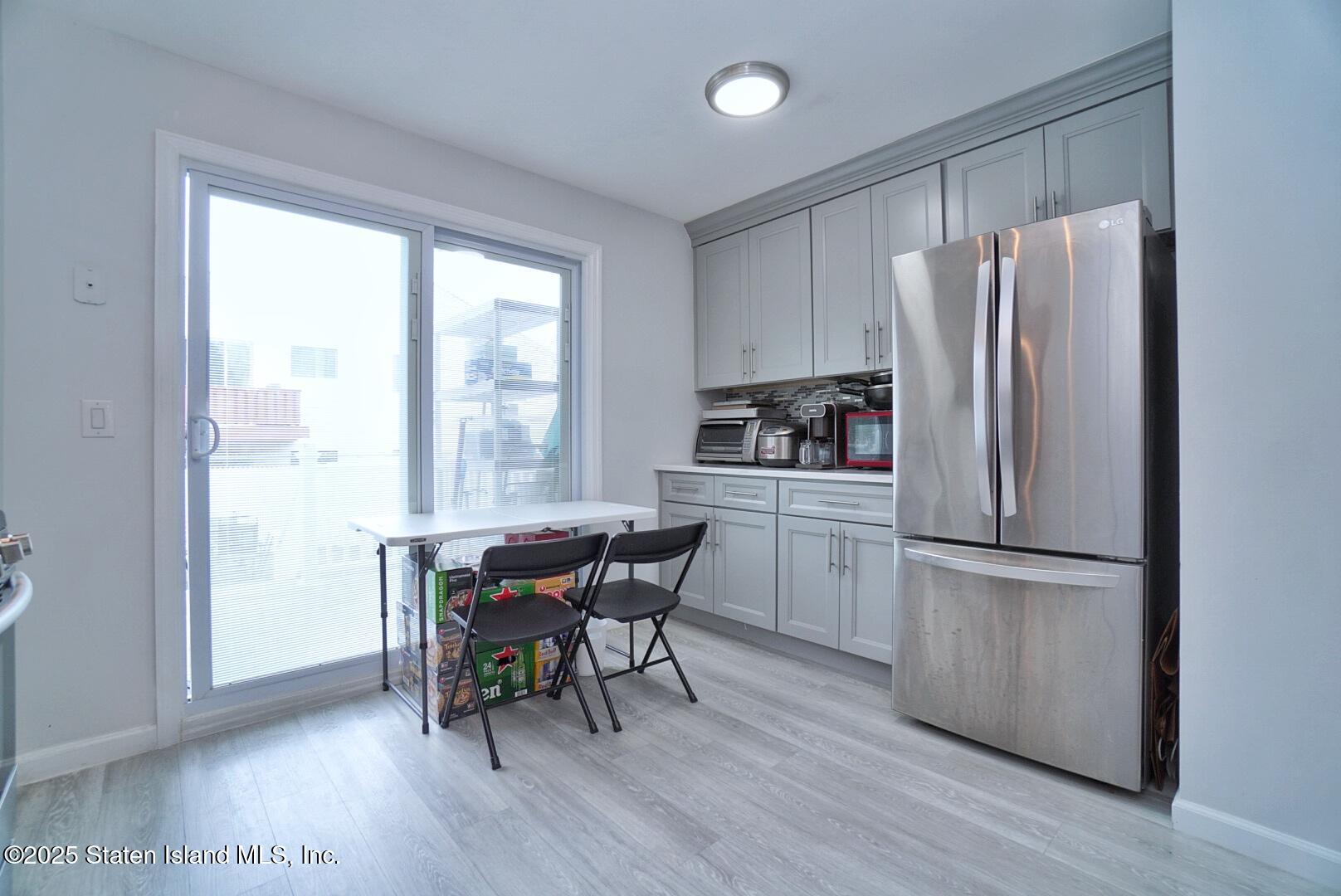 168 Rosedale Avenue Staten Island, NY 10312 - Photo 9 of 21 a kitchen with a refrigerator a table and chairs