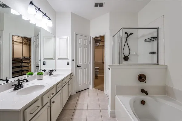 a bathroom with a double vanity sink a mirror a bathtub and shower