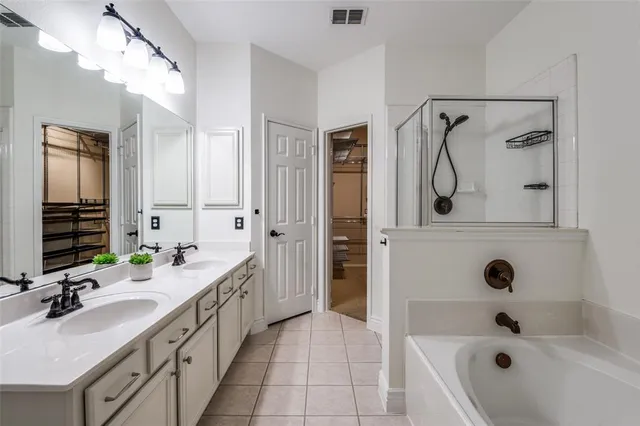 a bathroom with a double vanity sink a mirror a bathtub and shower
