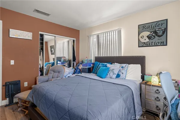 a bedroom with a bed and wooden floor
