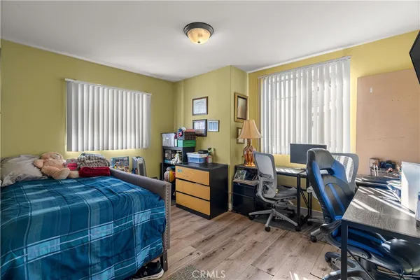 a bedroom with two beds and a desk