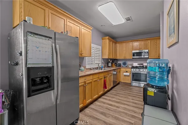 a kitchen with stainless steel appliances granite countertop a refrigerator a stove and a sink