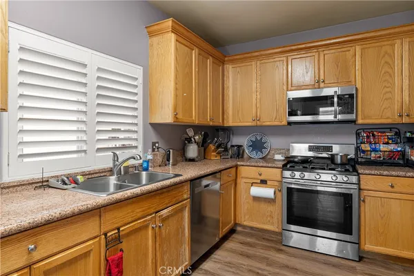 a kitchen with stainless steel appliances granite countertop a sink a stove and cabinets