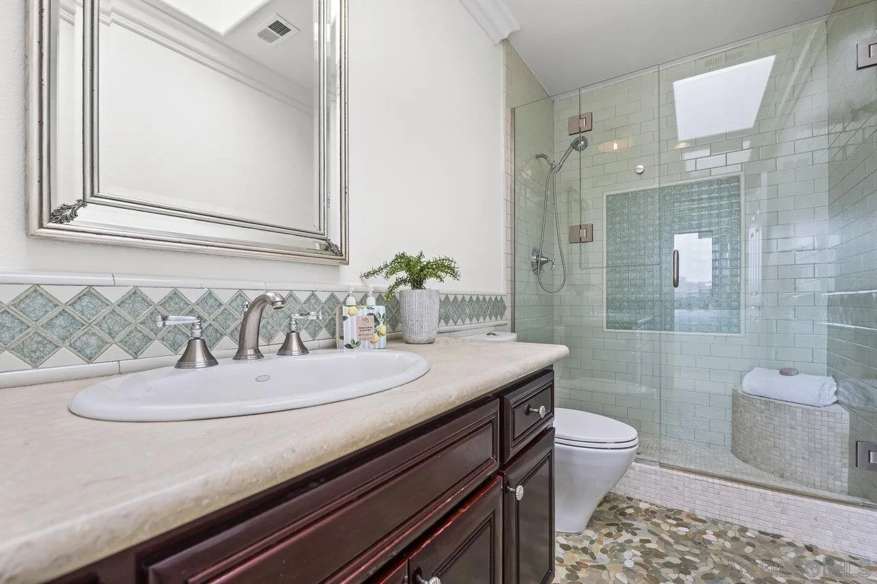1528 Summit Avenue Cardiff, CA 92007 - Photo 10 of 13 a bathroom with a granite countertop sink a toilet a mirror and shower