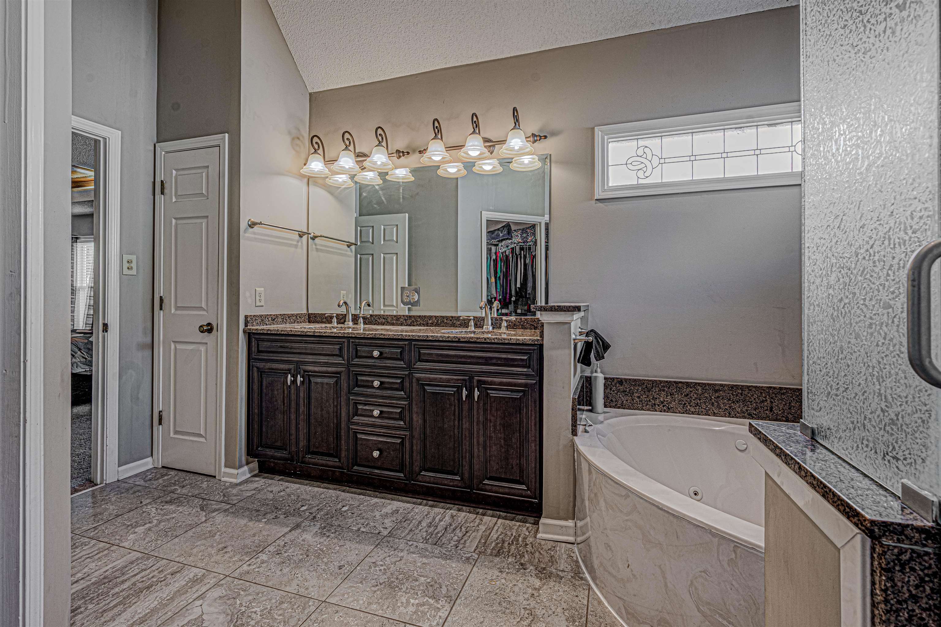 765 Pine Grove Cove Collierville, TN 38017 - Photo 20 of 31 a bathroom with a granite countertop bathtub a sink and a mirror