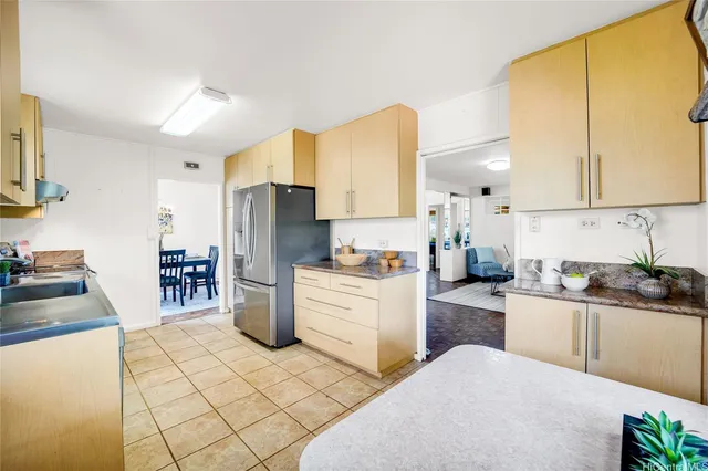 a kitchen with a sink a stove top oven a refrigerator and cabinetry