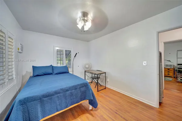 a bedroom with a bed and wooden floor