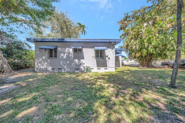 a backyard of a house with outdoor seating and trees