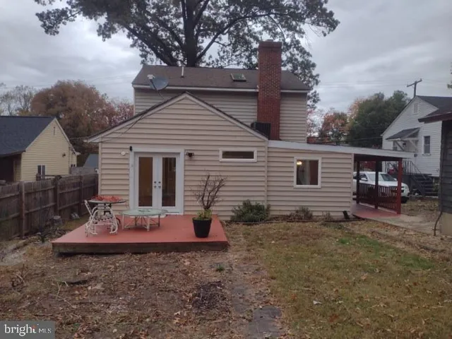 a view of a backyard with potted plants and large trees