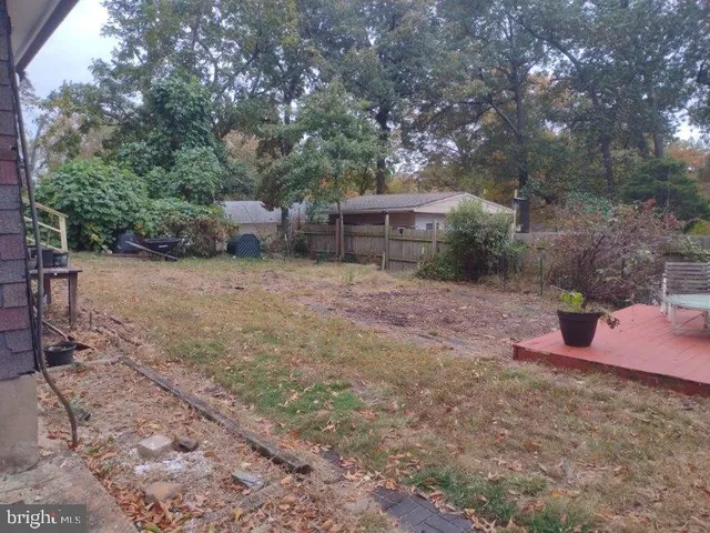 a view of a house with a yard and large tree