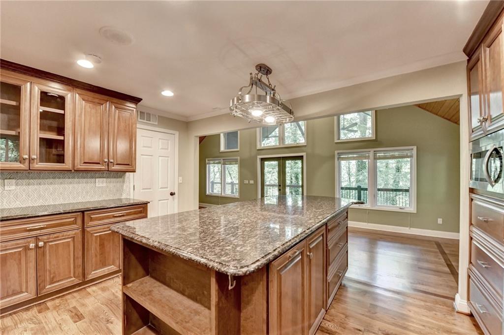 975 Timber Lake Trail Cumming, GA 30041 - Photo 31 of 82 a kitchen with granite countertop center island wooden floor and stainless steel appliances