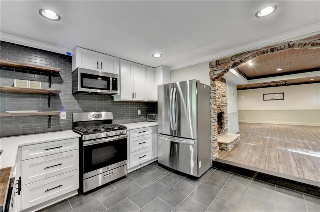 975 Timber Lake Trail Cumming, GA 30041 - Photo 53 of 82 a kitchen with stainless steel appliances a refrigerator a stove a microwave and cabinets
