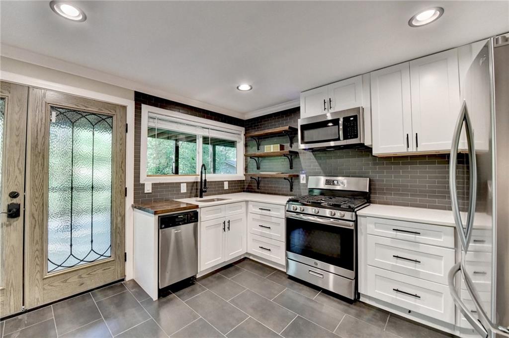 975 Timber Lake Trail Cumming, GA 30041 - Photo 55 of 82 a kitchen with stainless steel appliances granite countertop a stove and a microwave