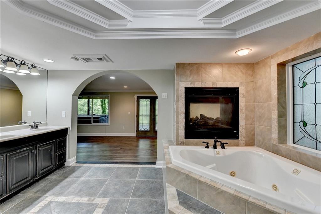 975 Timber Lake Trail Cumming, GA 30041 - Photo 65 of 82 a spacious bathroom with a tub sink and mirror