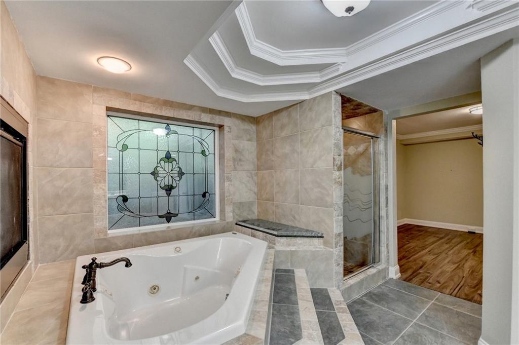 975 Timber Lake Trail Cumming, GA 30041 - Photo 67 of 82 a bathroom with a bathtub and a shower