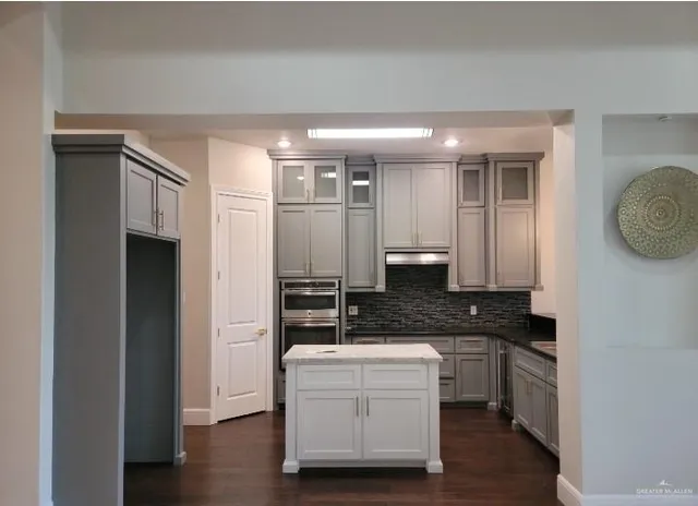 a large kitchen with a large window and stainless steel appliances