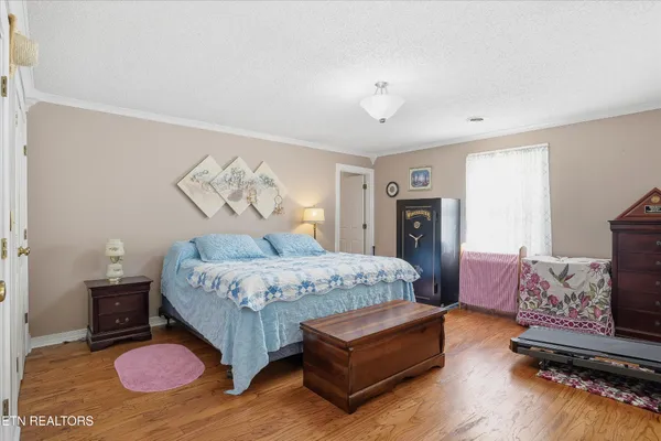 a spacious bedroom with a bed mirror and a window