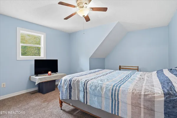 a bedroom with a bed and a flat tv screen on the dresser