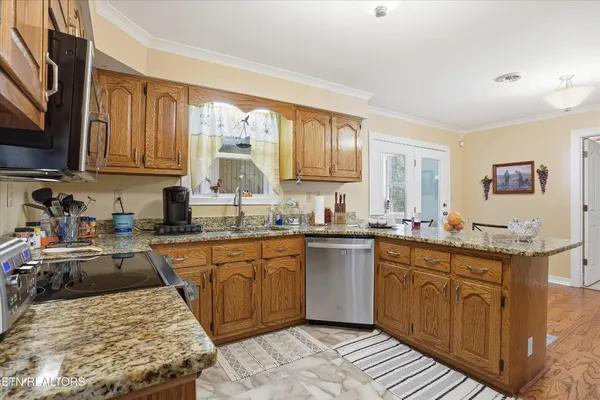 a kitchen with stainless steel appliances granite countertop sink stove top oven and cabinets