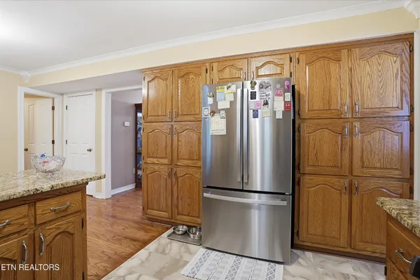 a kitchen with stainless steel appliances granite countertop a refrigerator and a stove top oven
