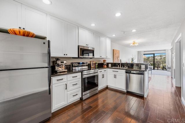a kitchen with white cabinets and white appliances