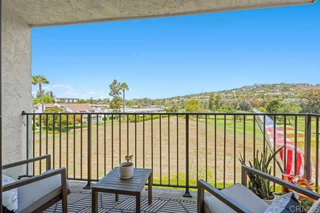 a view of a balcony with furniture and a floor to ceiling window