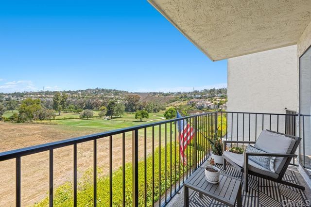 a balcony with wooden floor and city view