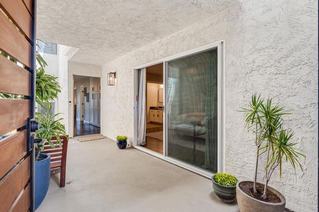 a living room with furniture and potted plants