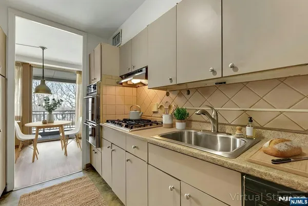 a kitchen with stainless steel appliances granite countertop a sink stove and cabinets