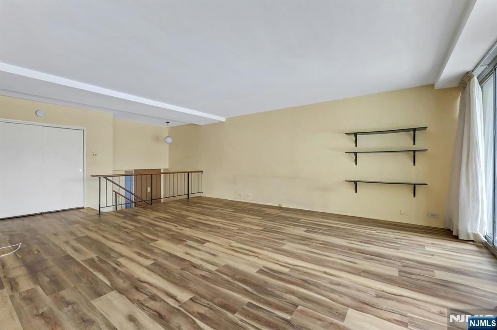 2 Horizon Road, Unit G5 Fort Lee, NJ 07024 - Photo 11 of 46 a view of an empty room with wooden floor and a window