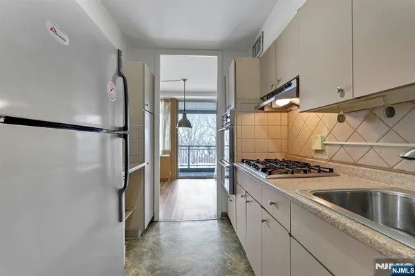 a kitchen with stainless steel appliances a refrigerator and a stove top oven