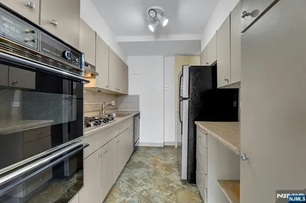a kitchen with a refrigerator and a stove top oven