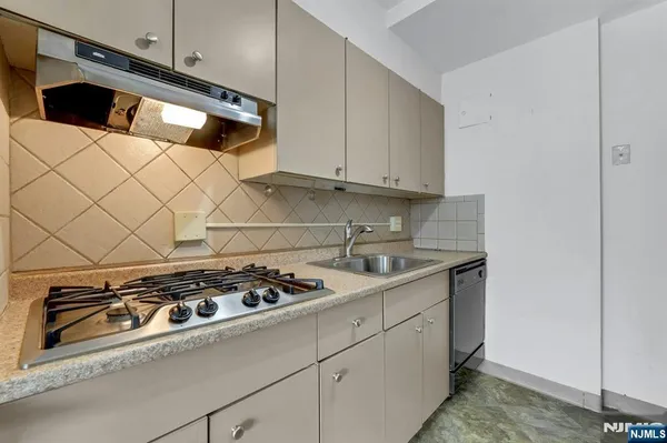 a kitchen with a stove and white cabinets